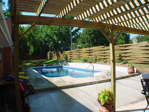 A large swimming pool with a pergola over it