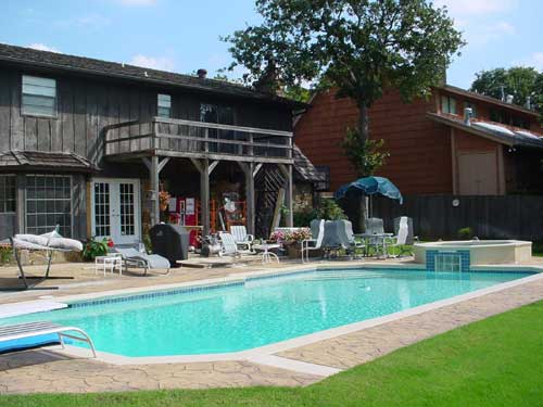 A large swimming pool in the backyard of a house