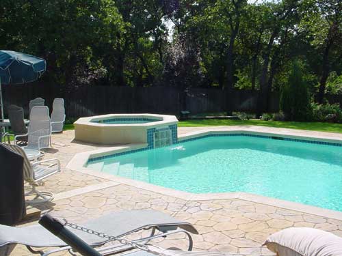 A large swimming pool with a hot tub in the middle
