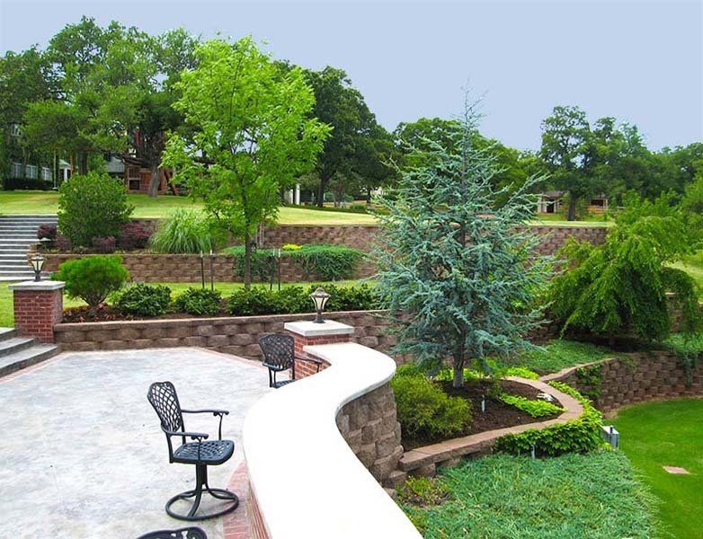 A patio with a chair and a tree in the background