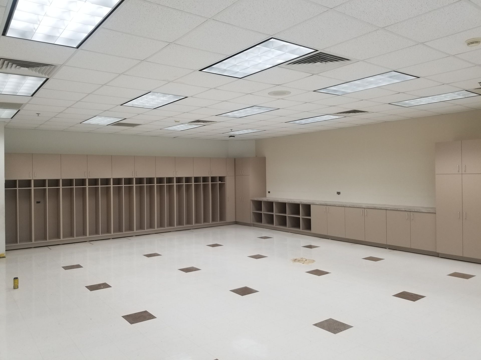 An empty locker room with lots of shelves and cabinets