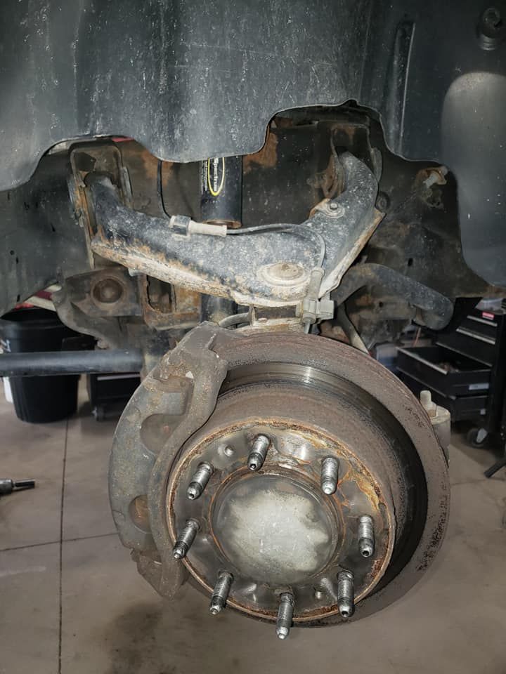 A close up of a brake disc on a truck in a garage.