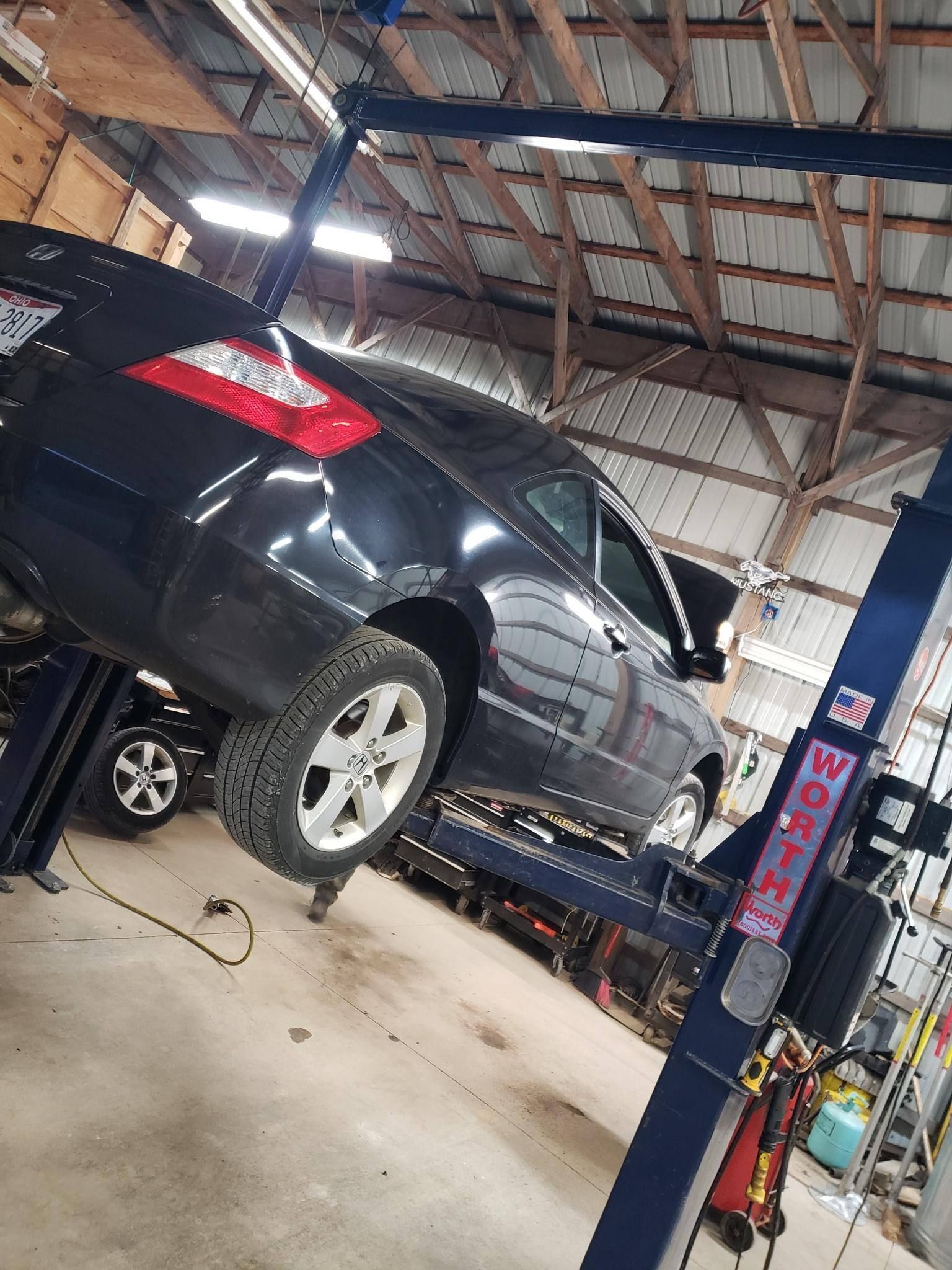 A car is sitting on a lift in a garage.