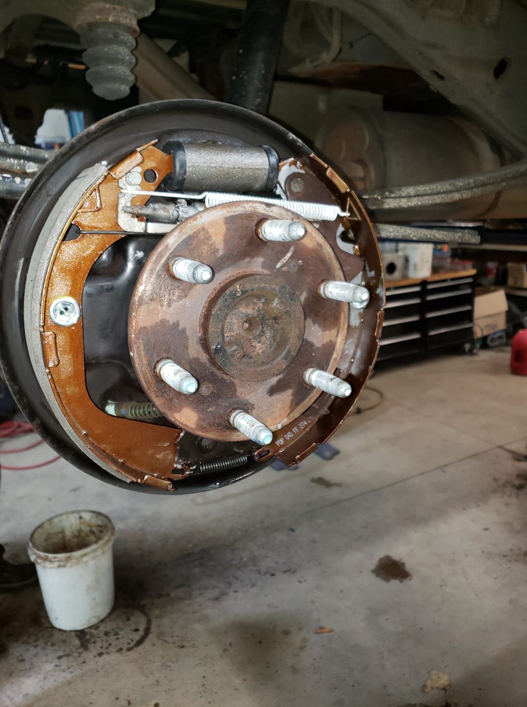 A close up of a brake disc on a car in a garage.