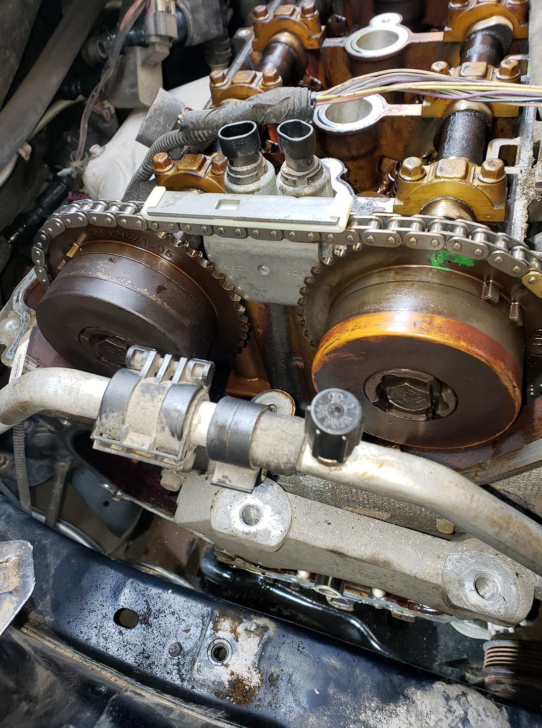 A close up of a car engine with a chain on it.