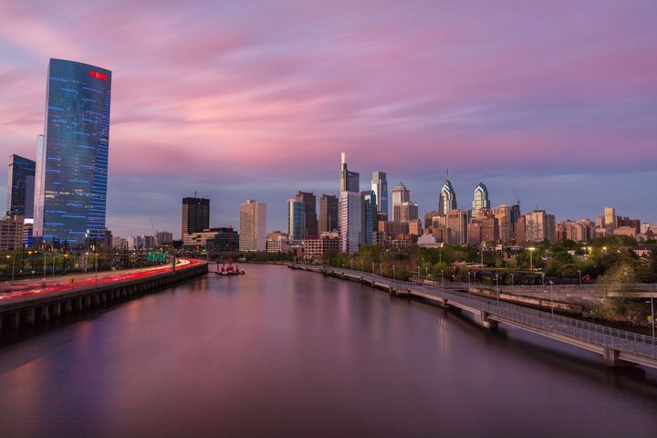 There is a river in the foreground and a city skyline in the background.