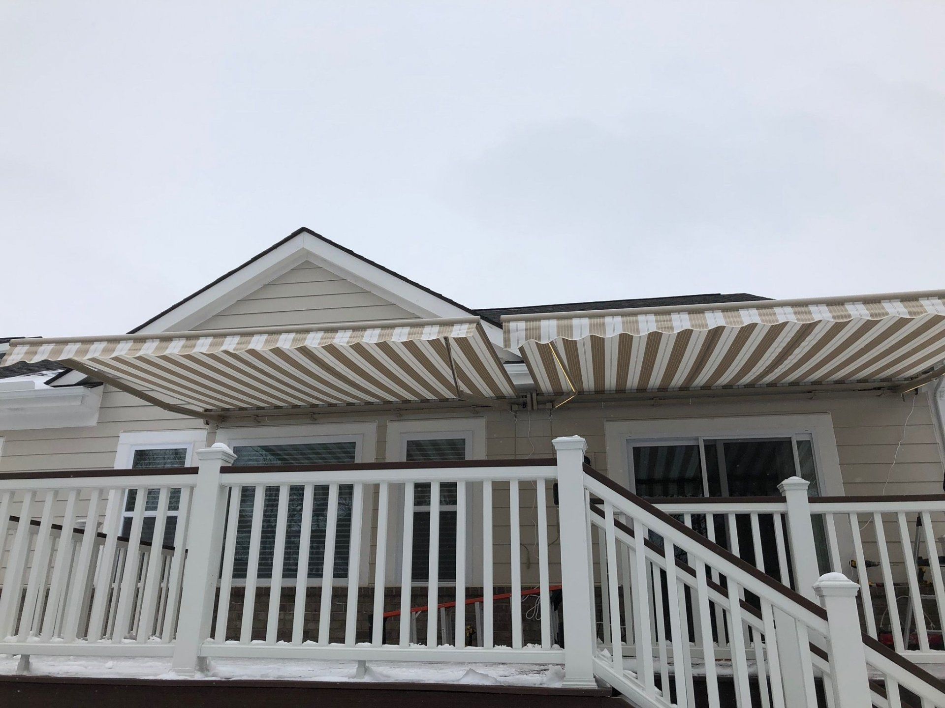 A house with a striped awning on the deck.