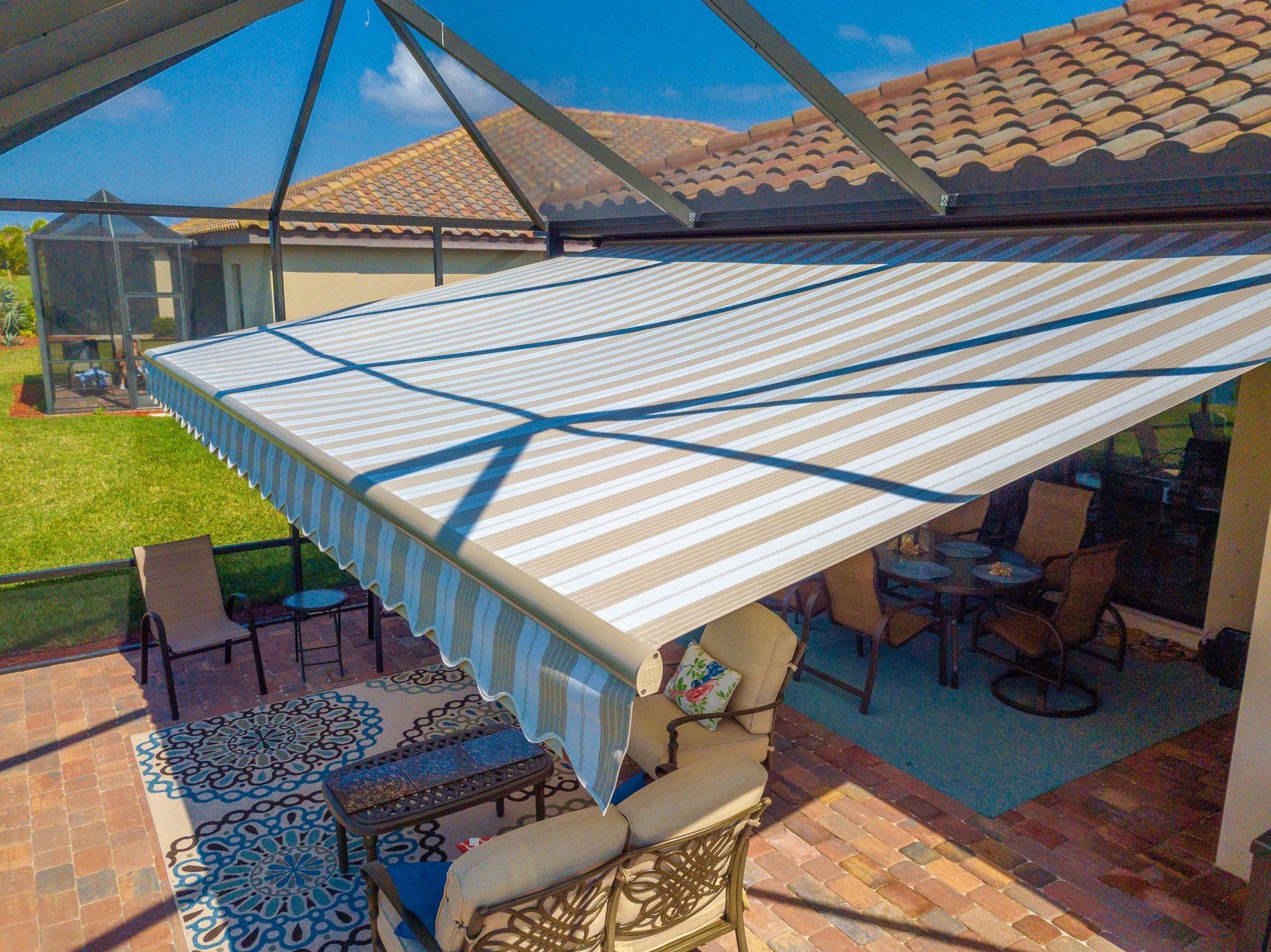 An aerial view of a patio with a striped awning over it.