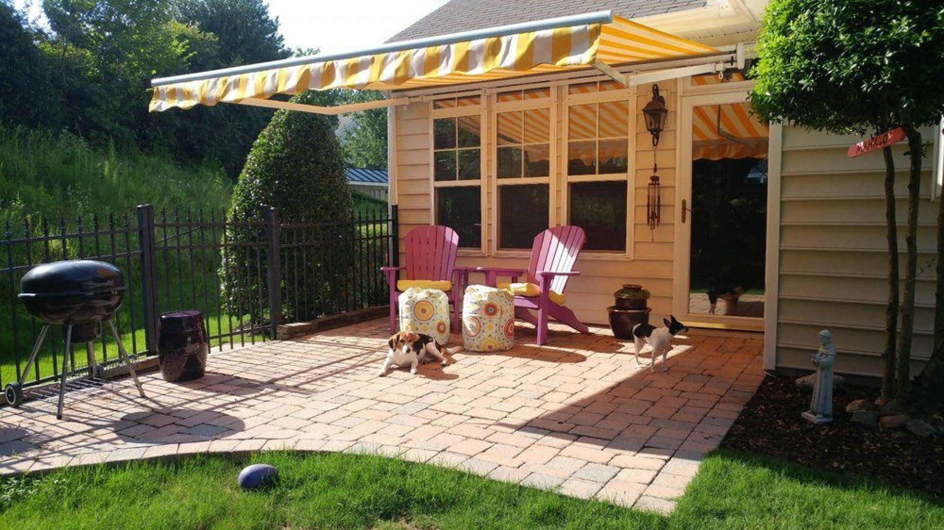 A patio with a yellow and white awning over it