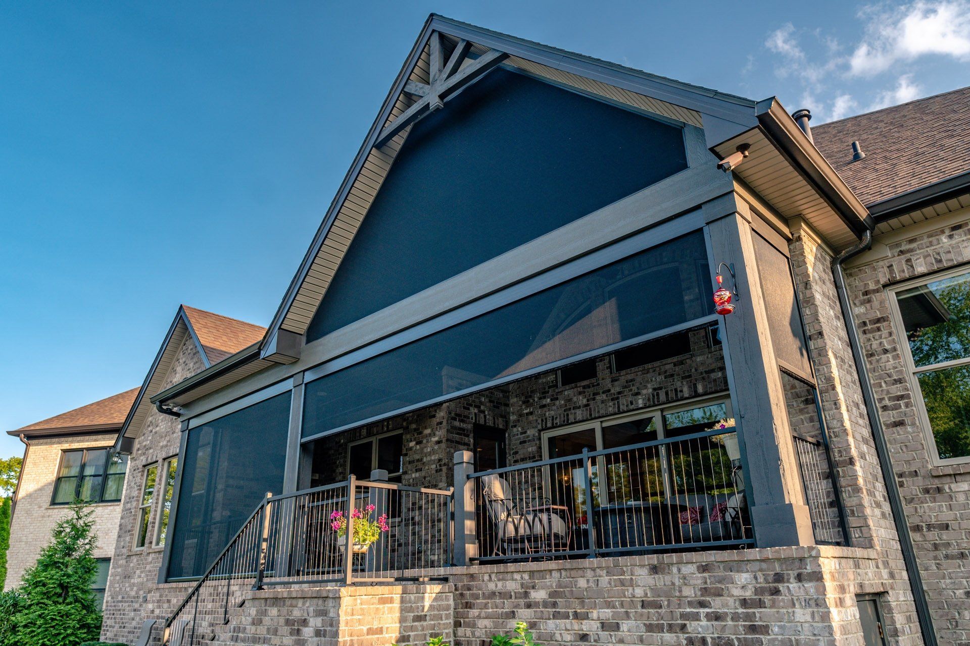 A large brick house with a screened in porch.