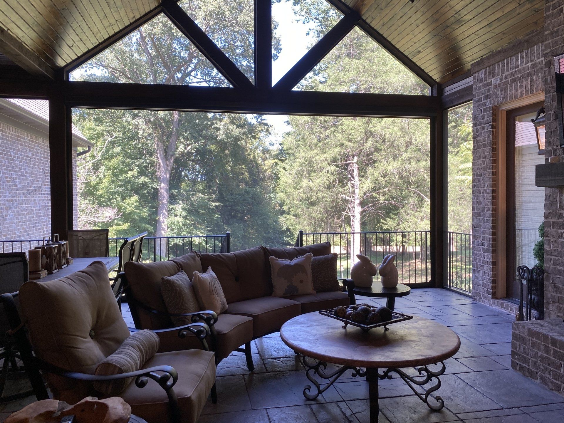 A screened in porch with a couch and chairs