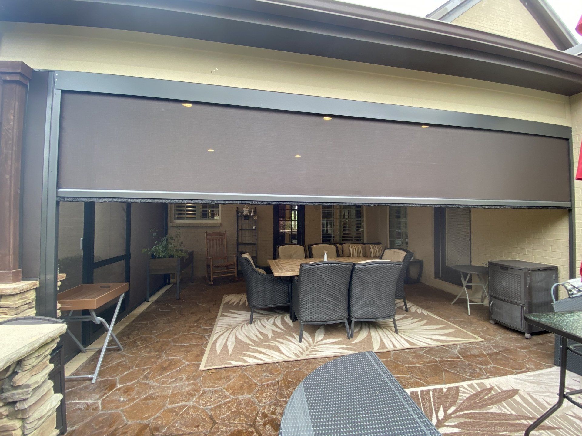 A patio with a dining table and chairs and a sliding screen door.