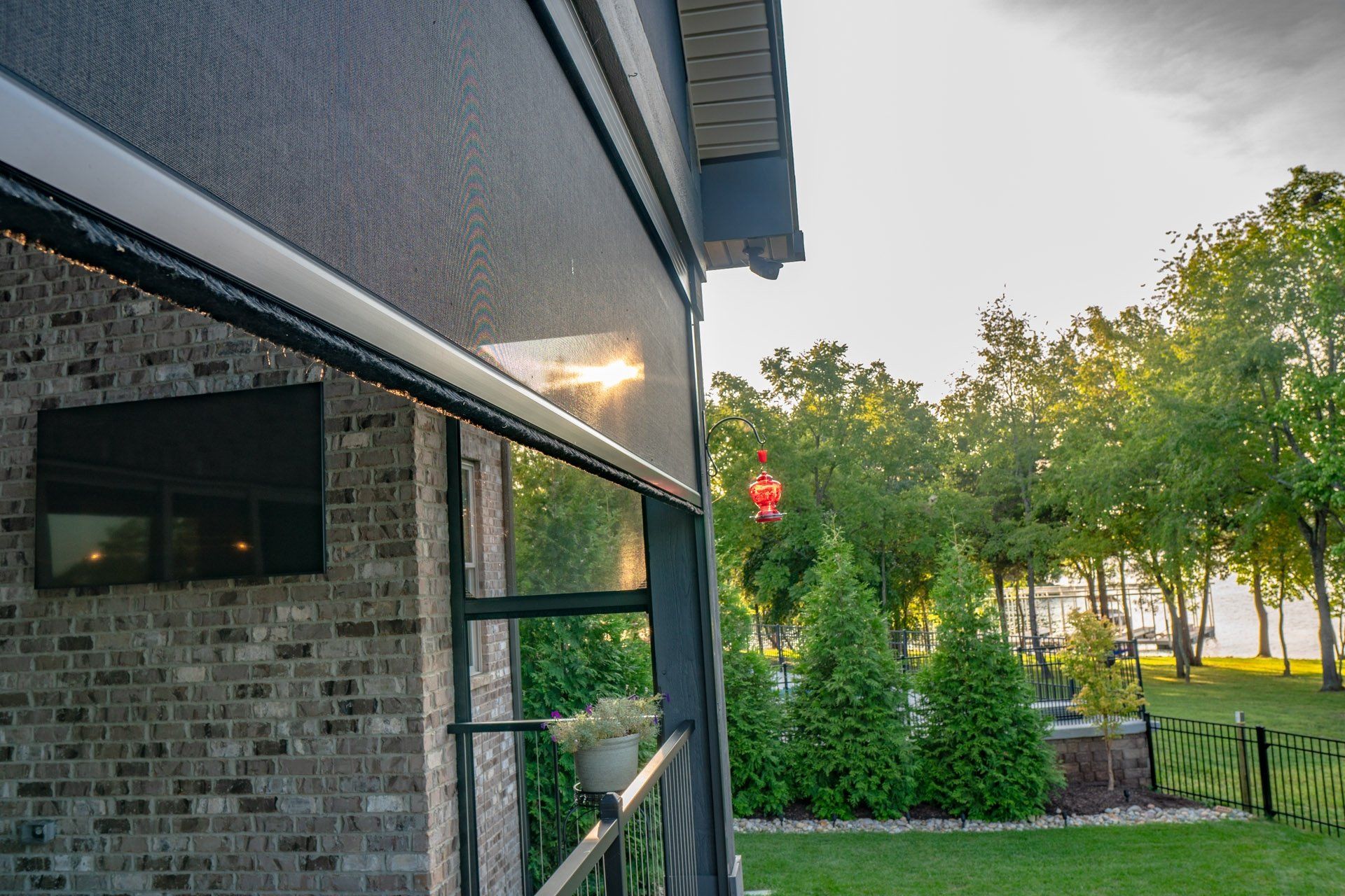 A house with a screened in porch and a brick wall.