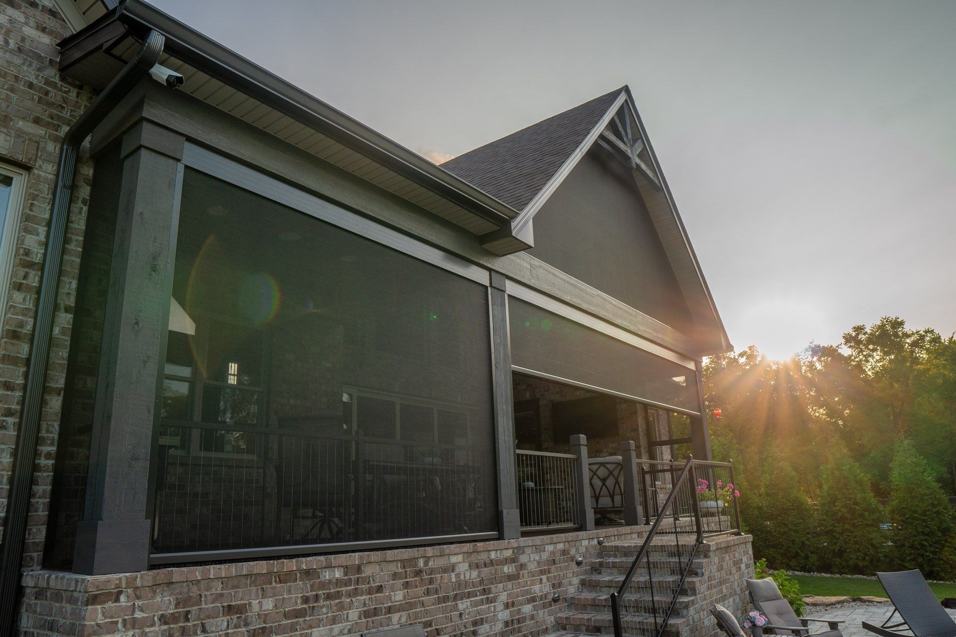 A large house with a screened in porch and stairs.