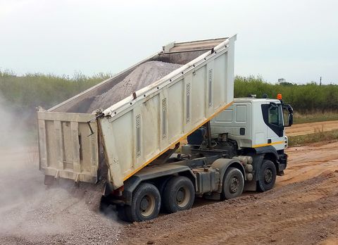 Dump Trucks — Gravel Being Unloaded in the Dump Truck in Staten Island, NY