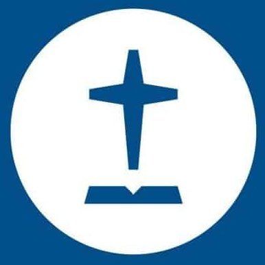 A blue cross floating above an open book on a white circular background.
