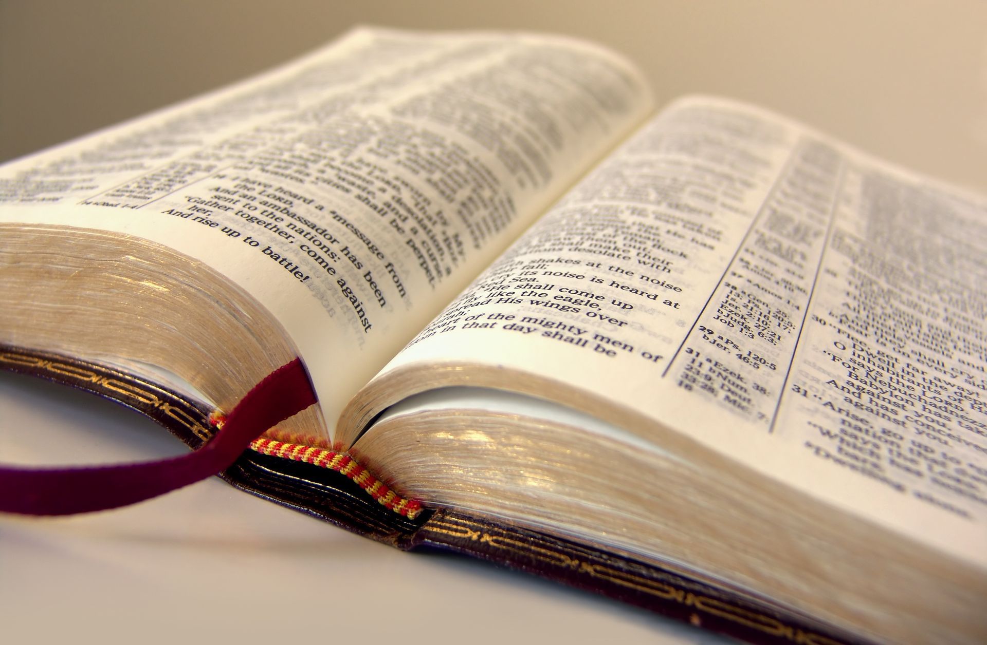 A close up of an open bible with a red bookmark
