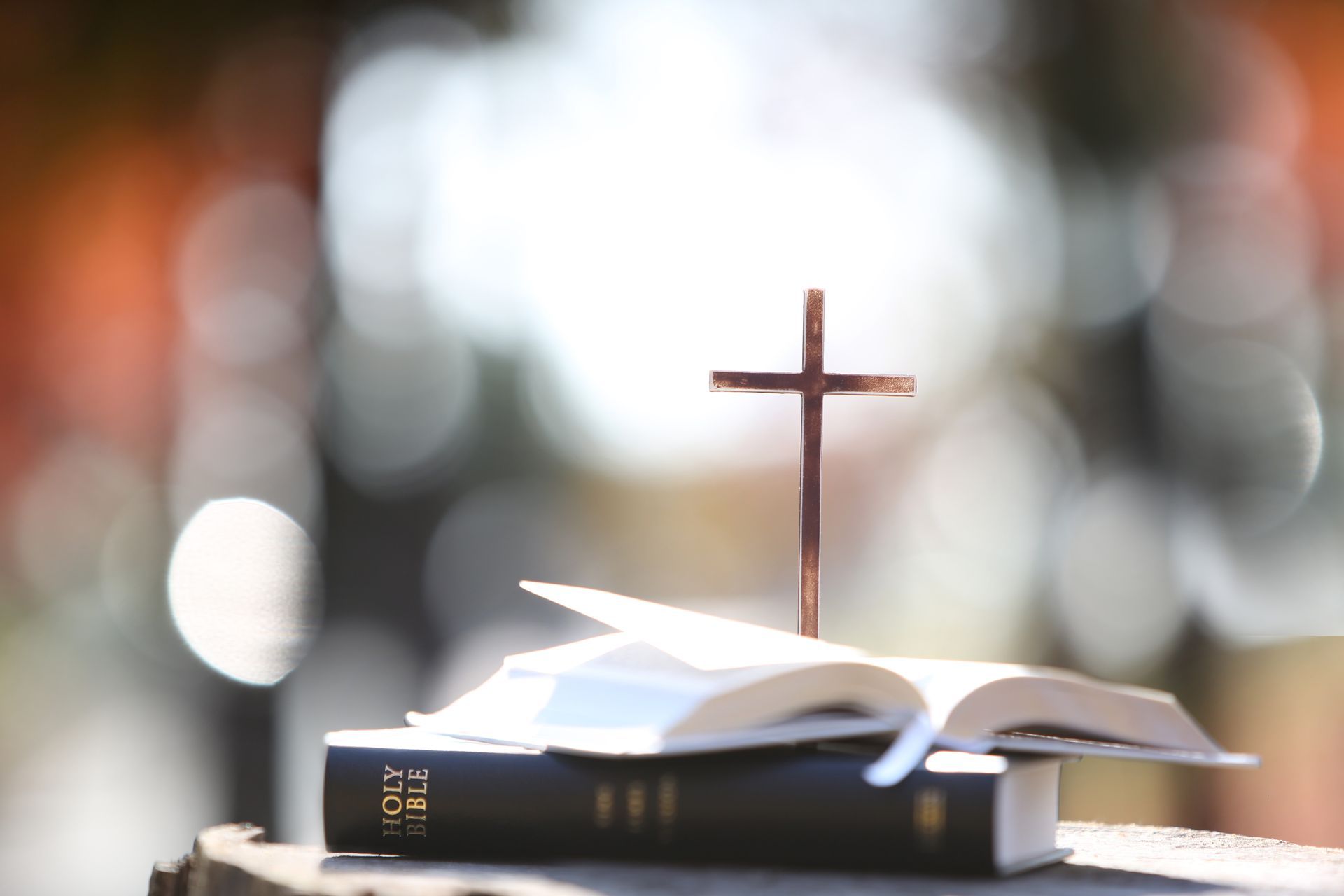 A cross is sitting on top of an open bible.