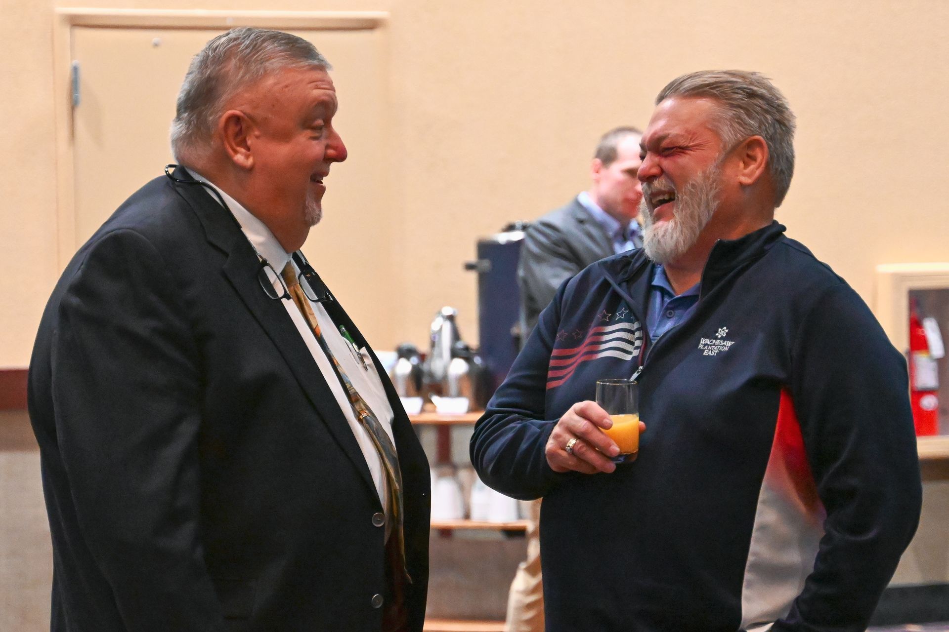 Two men are standing next to each other and talking