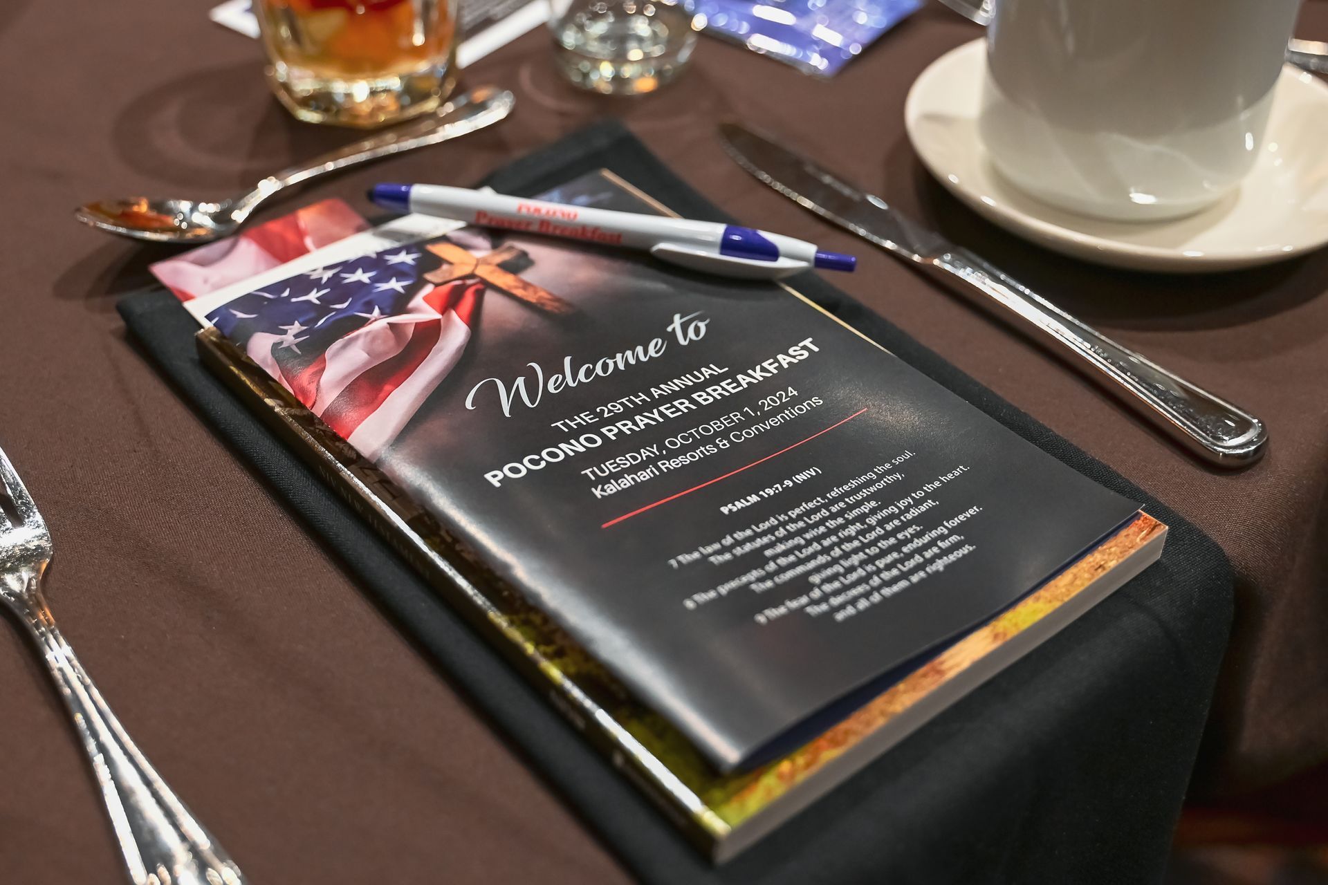 A menu is sitting on a table next to a cup of coffee.