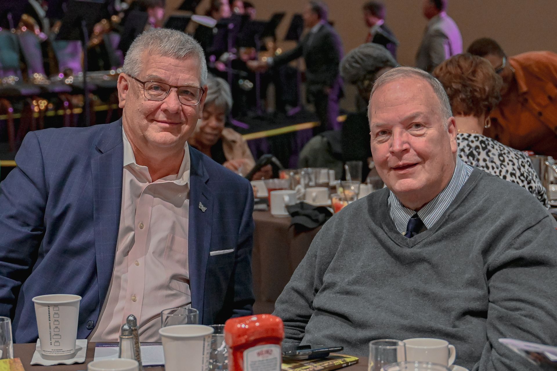 Two men are sitting at a table in a restaurant.