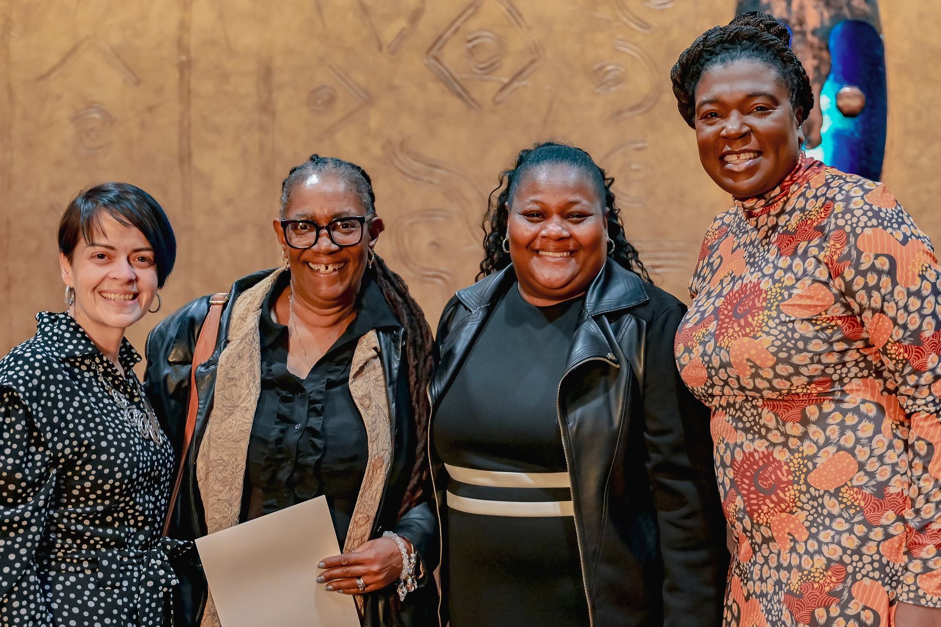 A group of women are posing for a picture together and smiling.