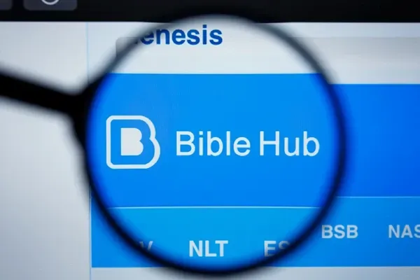 A magnifying glass is looking at the bible hub website