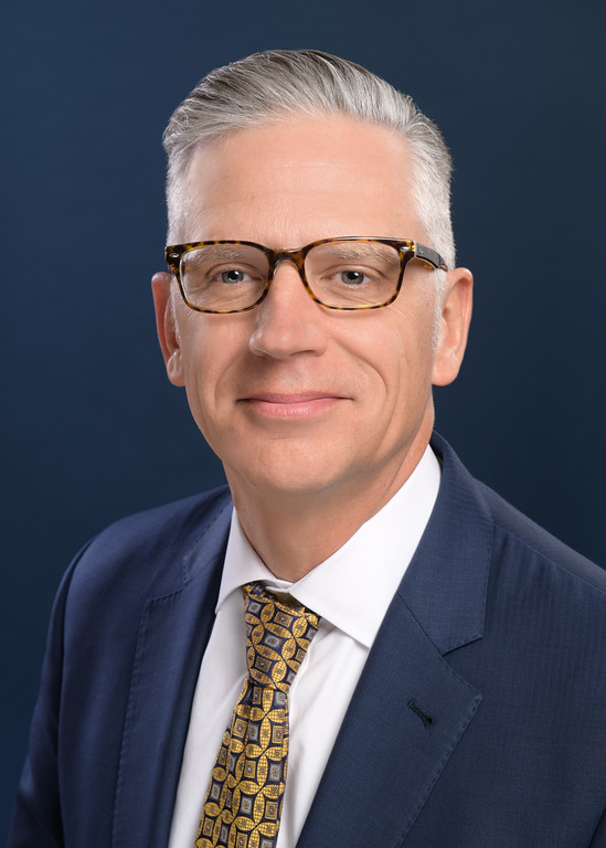 A man in a suit and tie is wearing glasses.
