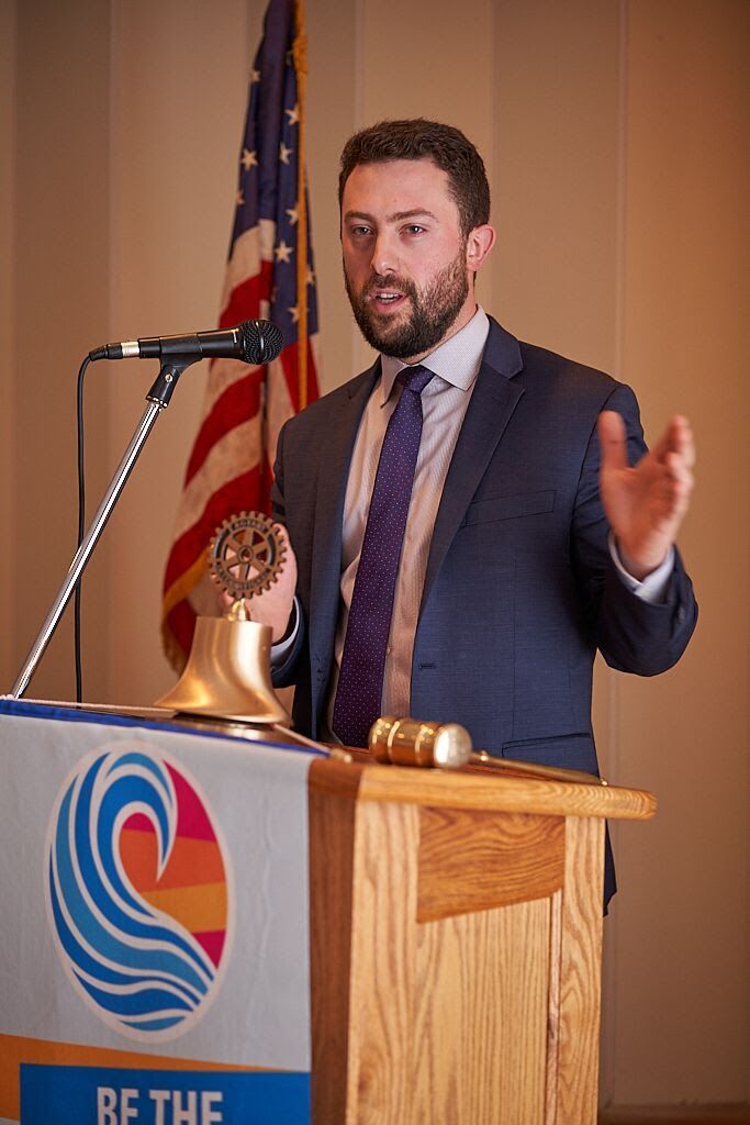 A man in a suit and tie is standing at a podium giving a speech.