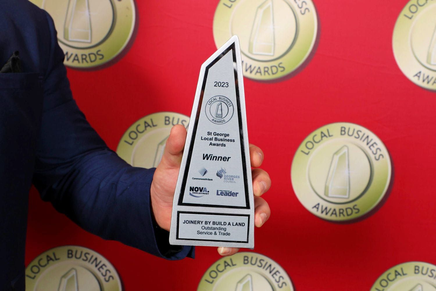 a man in a suit is holding a local business award