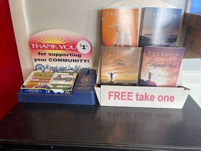 A countertop display with free pamphlets about freedom. Beside it is a donation box and a sign thanking for community support. |  Johnson's Automotive