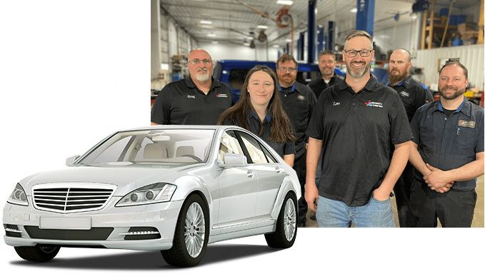 Silver car in front of a team of mechanics in a garage setting. | Johnson's Automotive