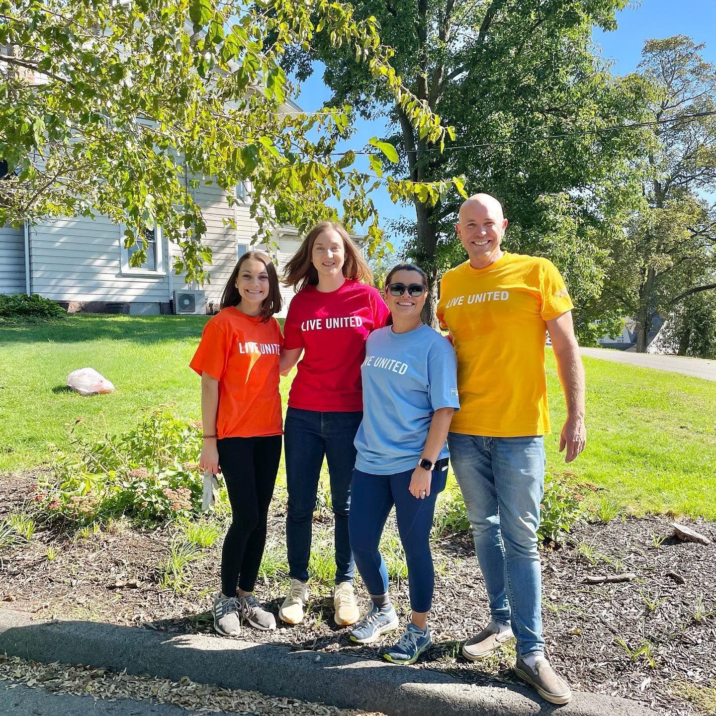 A group of people posing for a picture in front of a house