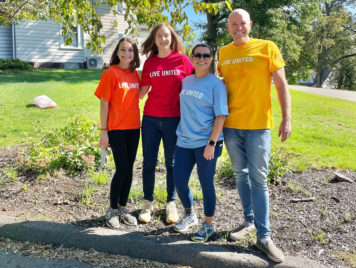 A group of people posing for a picture in front of a house