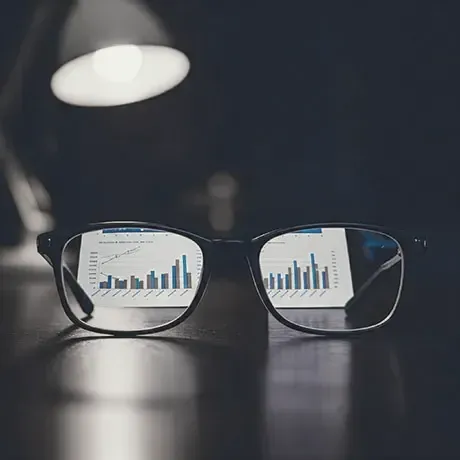 A pair of glasses sitting on top of a laptop computer.