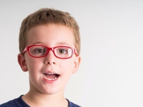 un bambino con degli occhiali da vista rossi