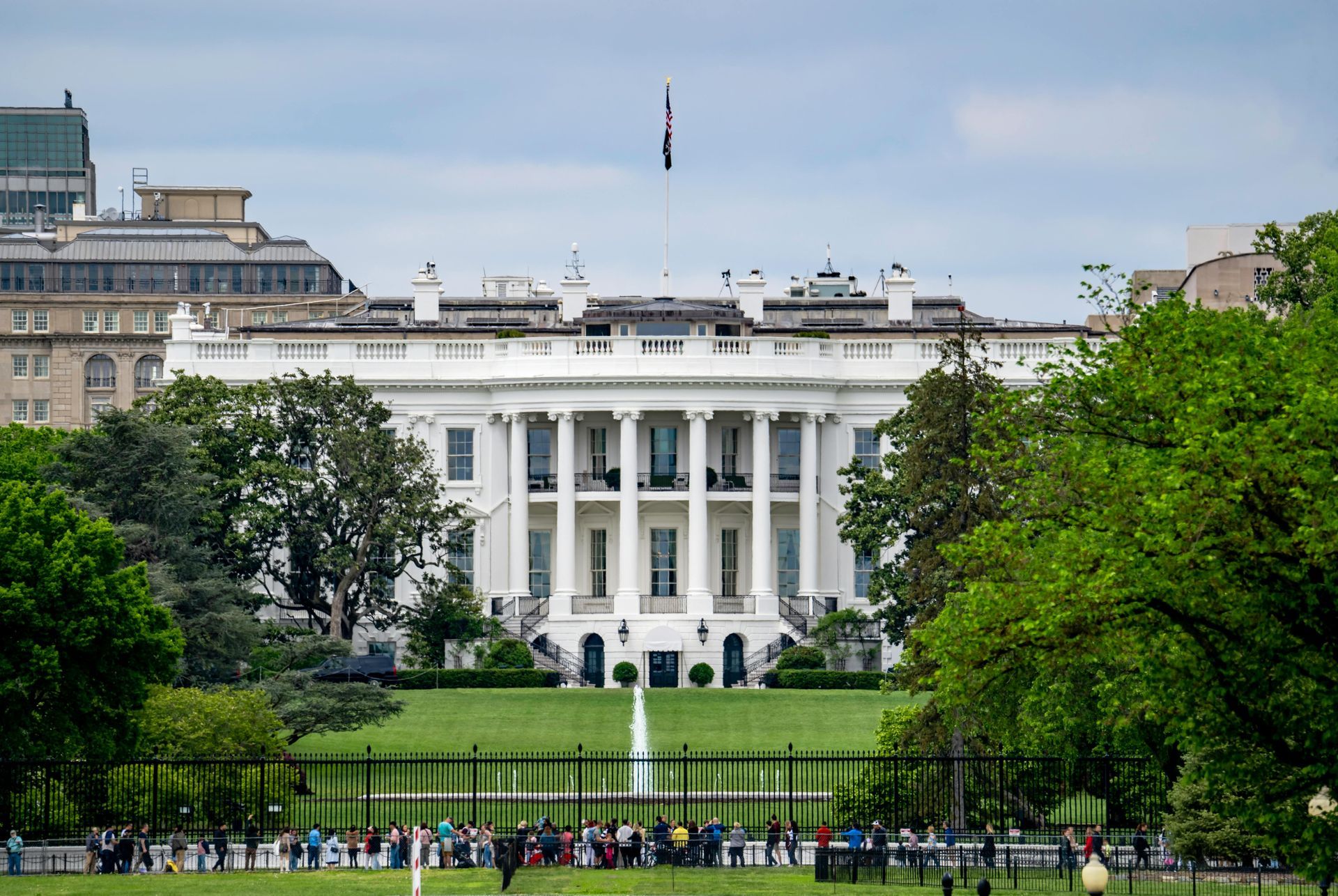 White House in Washington, D.C., seen from the South Lawn with trees and people in the foreground