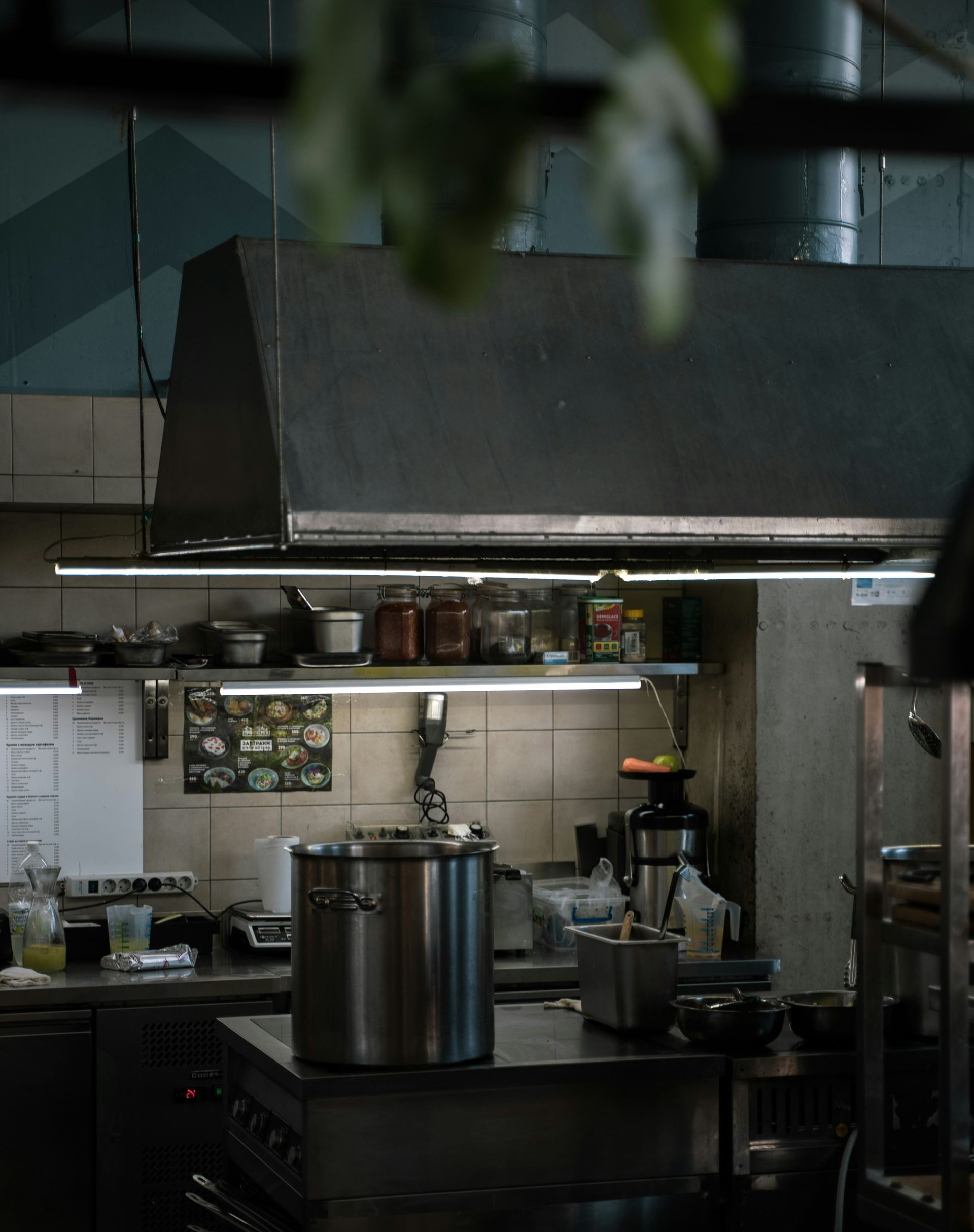 Commercial kitchen interior with stainless steel equipment and shelves.