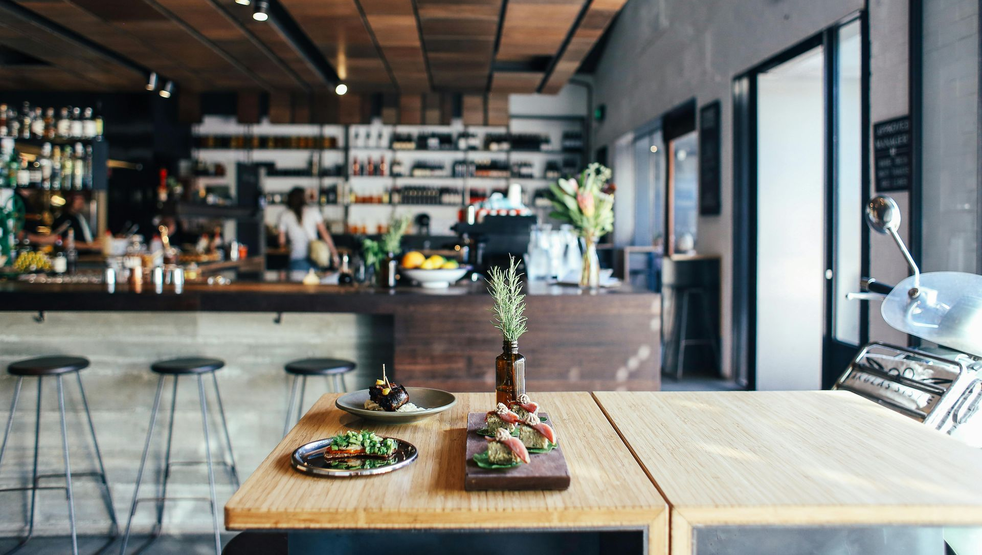 Cafe interior with a wooden ceiling, bar, and table with dishes.