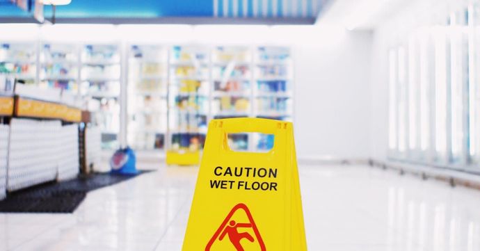 A yellow caution wet floor sign in a store.