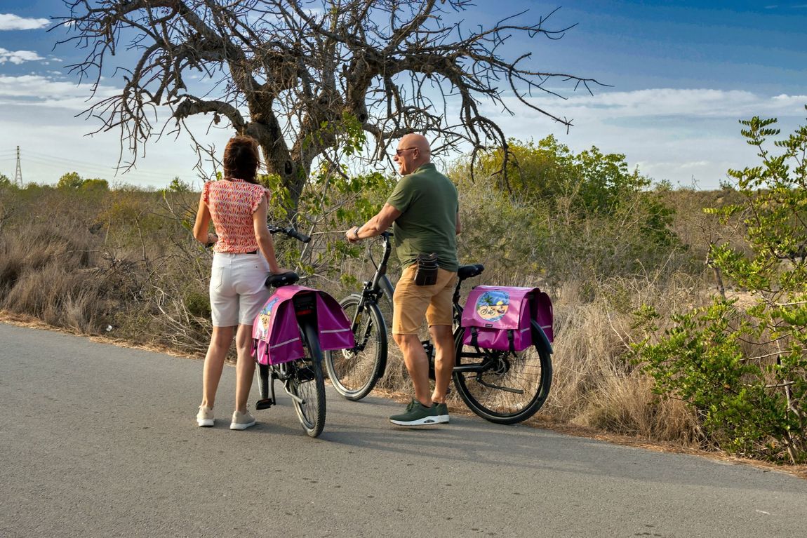 Een man en een vrouw staan ​​naast een fiets aan de kant van de weg.