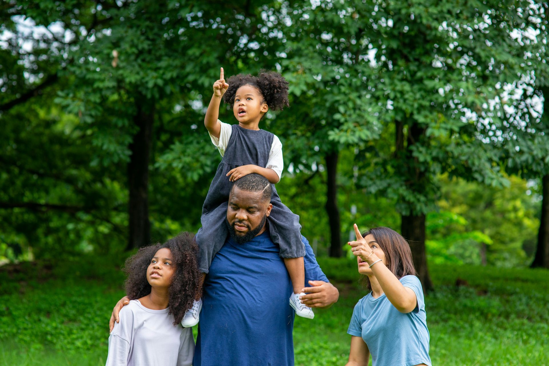 Man with glasses, writing at desk near a window. A small wind turbine model and a cup of coffee are on the table.