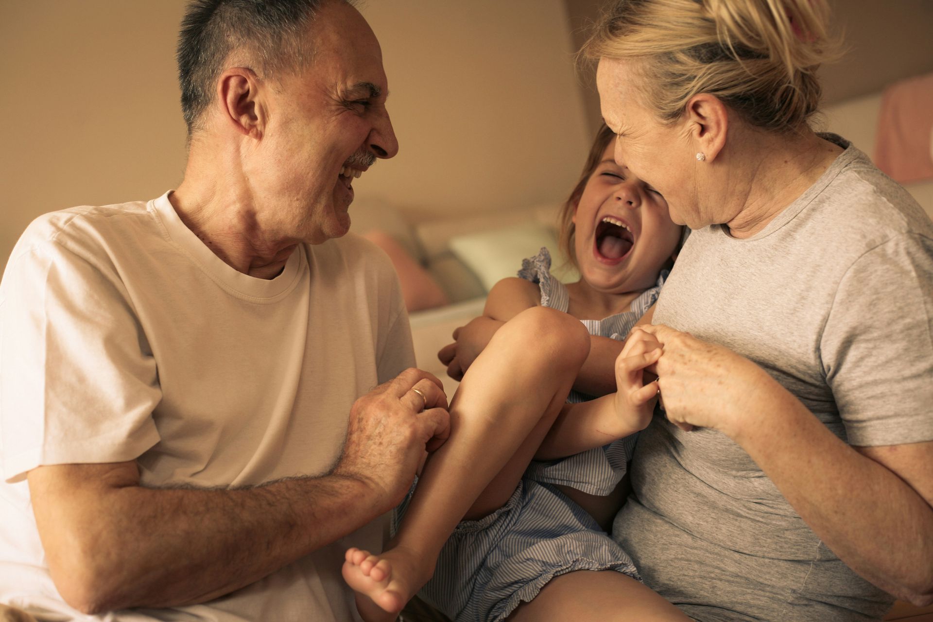 Man with glasses, writing at desk near a window. A small wind turbine model and a cup of coffee are on the table.
