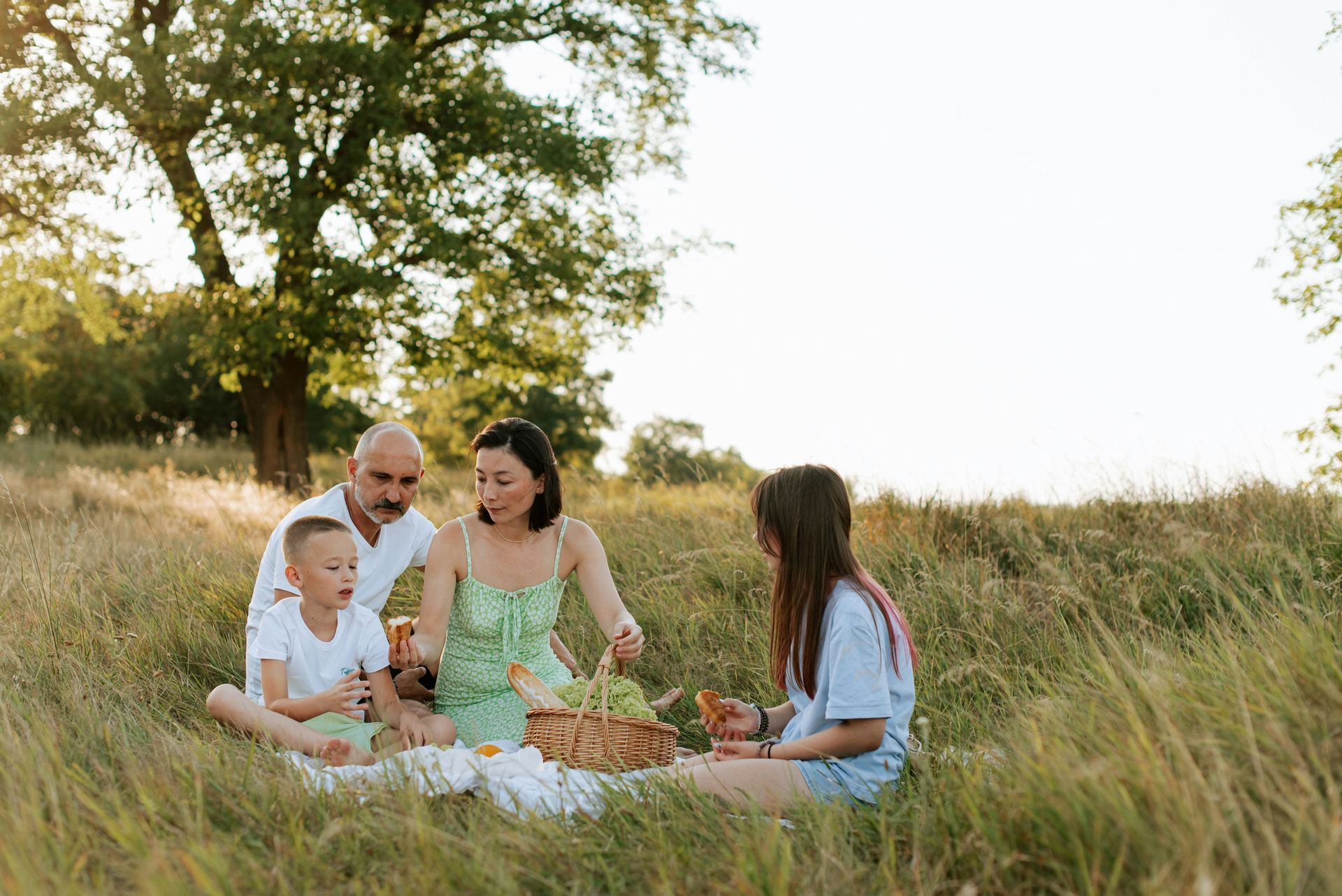 Man with glasses, writing at desk near a window. A small wind turbine model and a cup of coffee are on the table.