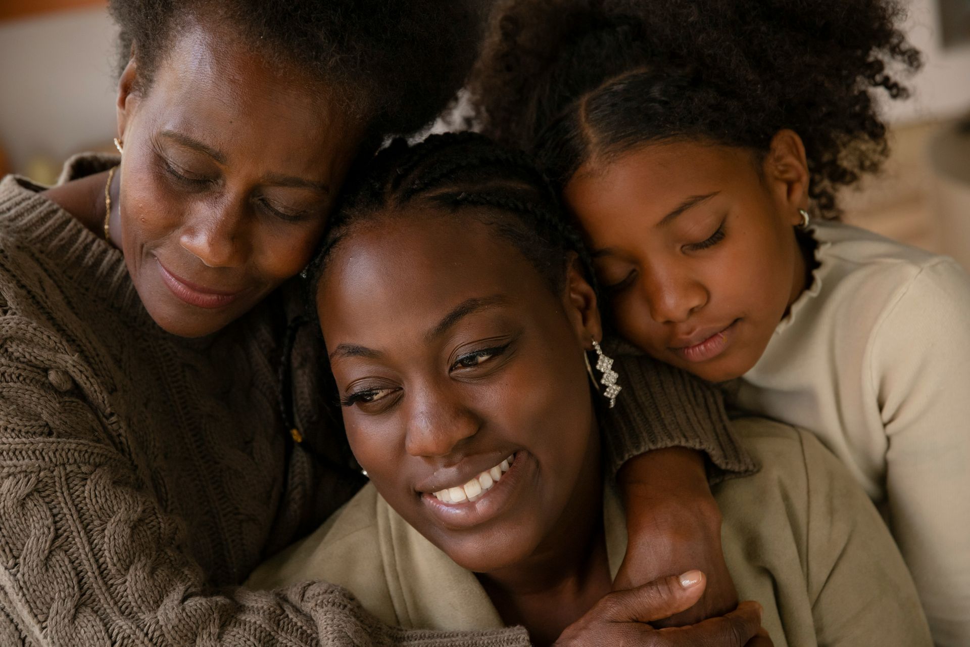 Man with glasses, writing at desk near a window. A small wind turbine model and a cup of coffee are on the table.