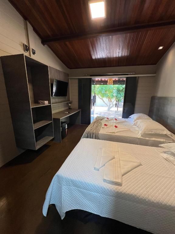 Um quarto de hotel com duas camas e uma televisão