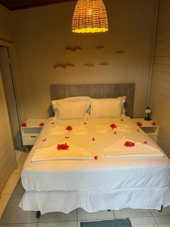 Um quarto com uma cama e duas mesas de cabeceira decoradas com flores e toalhas.