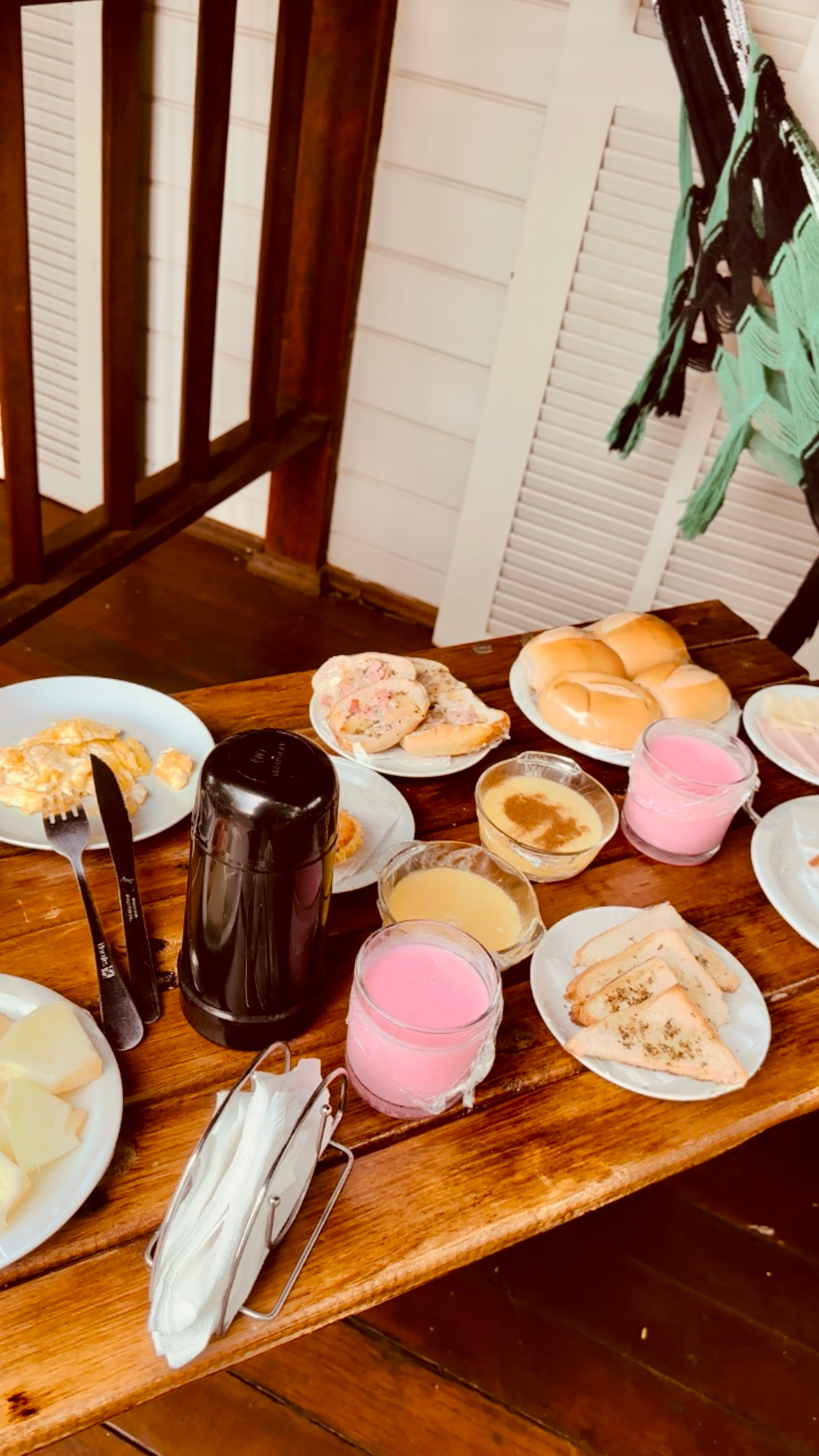 Uma mesa de madeira coberta com pratos de comida e bebidas.