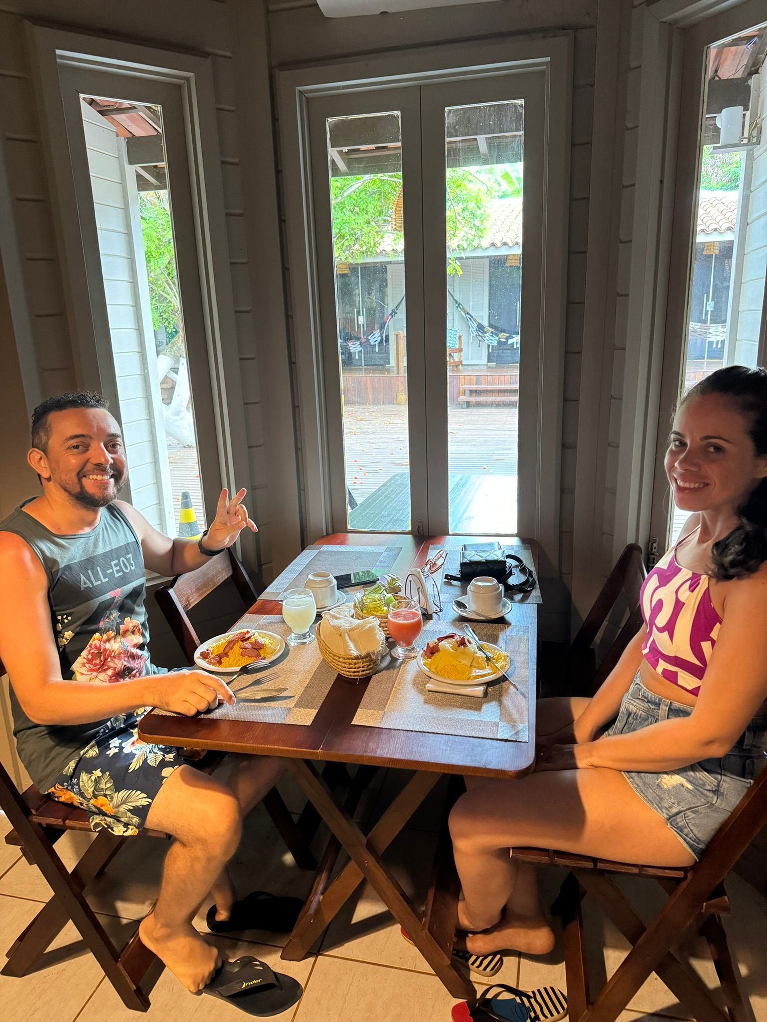 Um homem e uma mulher estão sentados à mesa com pratos de comida.