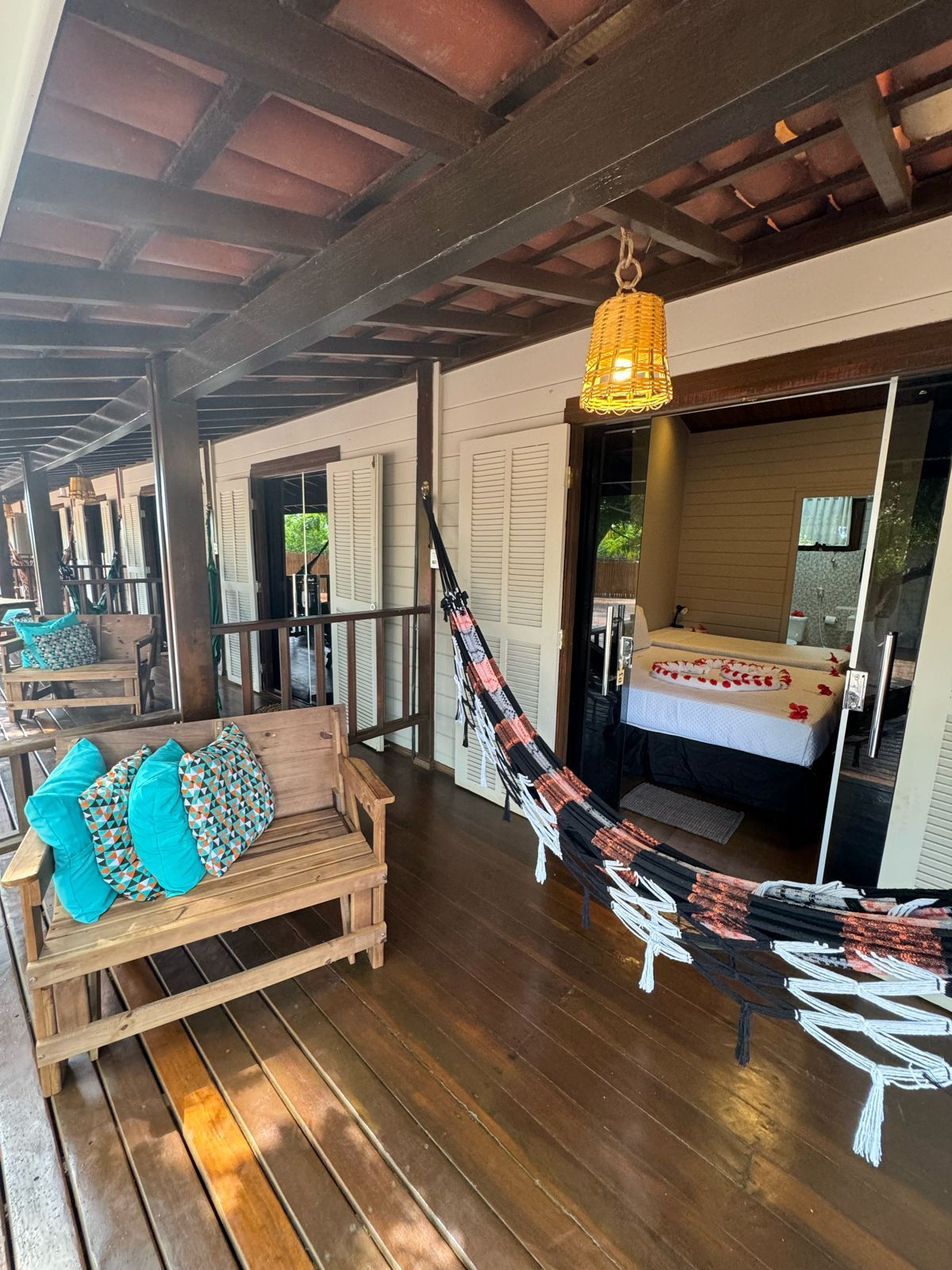 Há uma rede na varanda de um quarto de hotel.